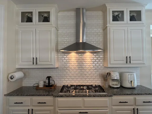 a kitchen with granite countertop a sink a island and chairs