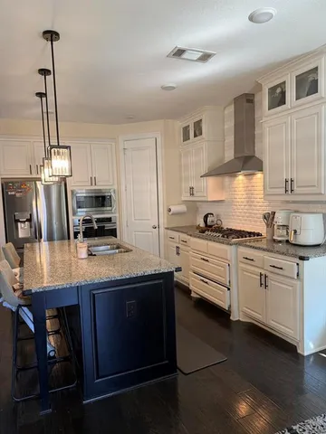 a kitchen with granite countertop cabinets and stove top oven