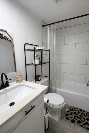 a bathroom with a sink a toilet a mirror and shower