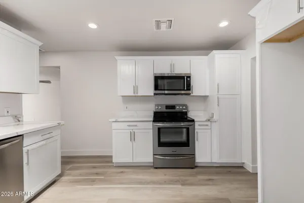 a kitchen with a sink stove and white cabinets