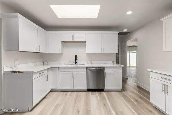 a kitchen with sink a microwave and cabinets
