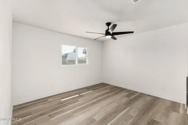 an empty room with a window and a ceiling fan