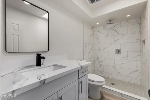 an empty room with wooden floor and ceiling fan