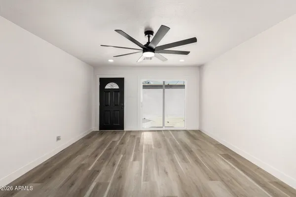 a view of a livingroom with a ceiling fan and wooden floor