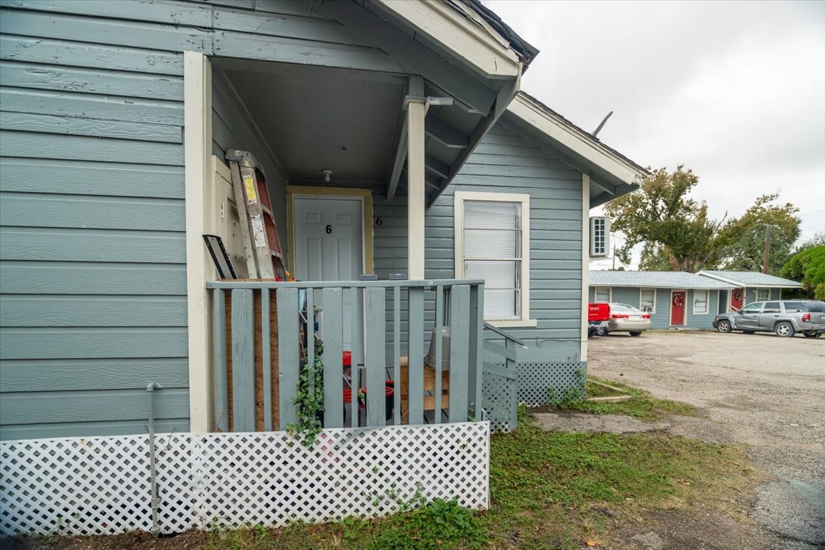 13928 Bandera Street Houston, TX 77015 - Photo 14 of 40 This view showcases the covered entry for Unit 6, complete with a small porch and railing. The thoughtful design provides shelter at the doorway and easy access from the shared courtyard area.