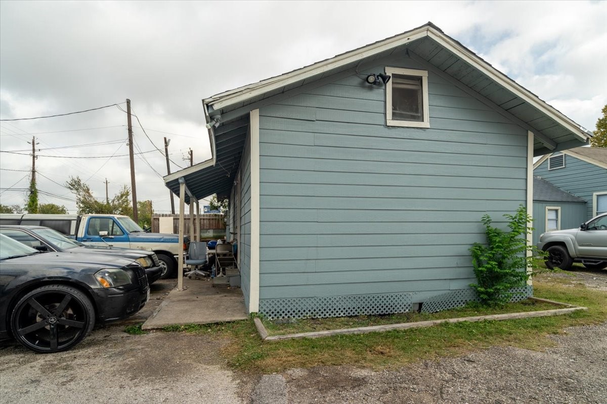 13928 Bandera Street Houston, TX 77015 - Photo 6 of 40 The side elevation highlights the charm and practicality of the property’s layout, featuring a covered walkway, tenant parking, and easy ground-level access. The well-maintained exterior and open surroundings emphasize a functional setup ideal for long-term renters.