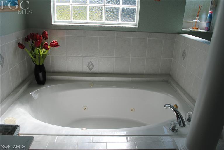 3325 Stringfellow Road, Unit A St. James City, FL 33956 - Photo 11 of 21 a bath tub sitting in a bathroom next to a window