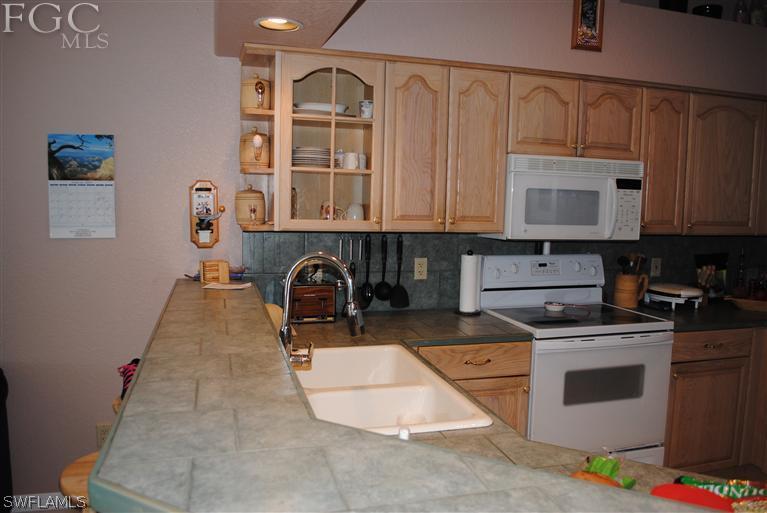 3325 Stringfellow Road, Unit A St. James City, FL 33956 - Photo 6 of 21 a kitchen with stainless steel appliances granite countertop a stove a sink and a microwave