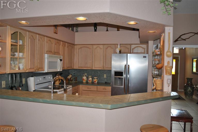 3325 Stringfellow Road, Unit A St. James City, FL 33956 - Photo 8 of 21 a kitchen with stainless steel appliances granite countertop a sink refrigerator and cabinets