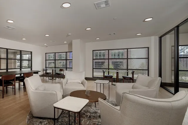 a dining room with furniture and a floor to ceiling window