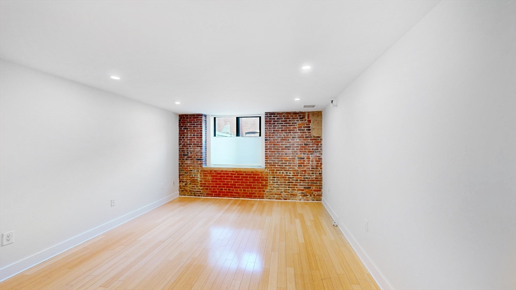 42 8th Street, Unit 2110 Boston, MA 02129 - Photo 2 of 10 a view of an empty room with wooden floor and a window