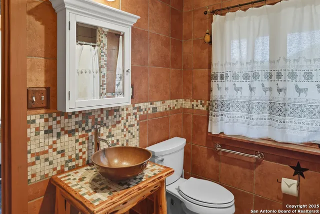 a bathroom with a toilet a sink and a mirror