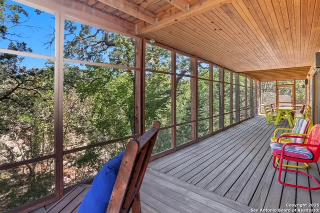 a balcony with wooden floor and outdoor seating