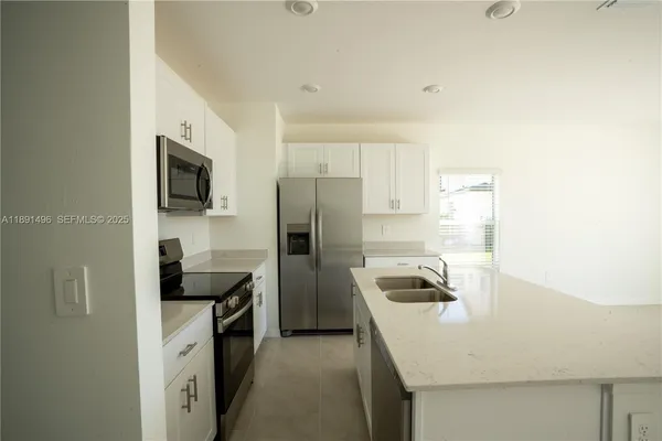 a kitchen with a refrigerator and a sink