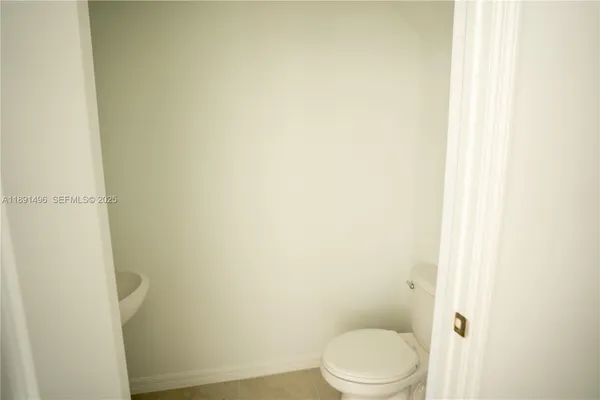 a white toilet sitting next to a shower