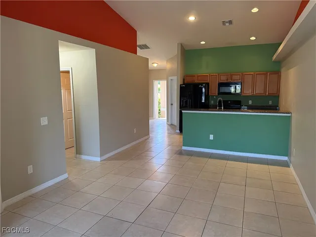 a view of kitchen with a refrigerator and a stove