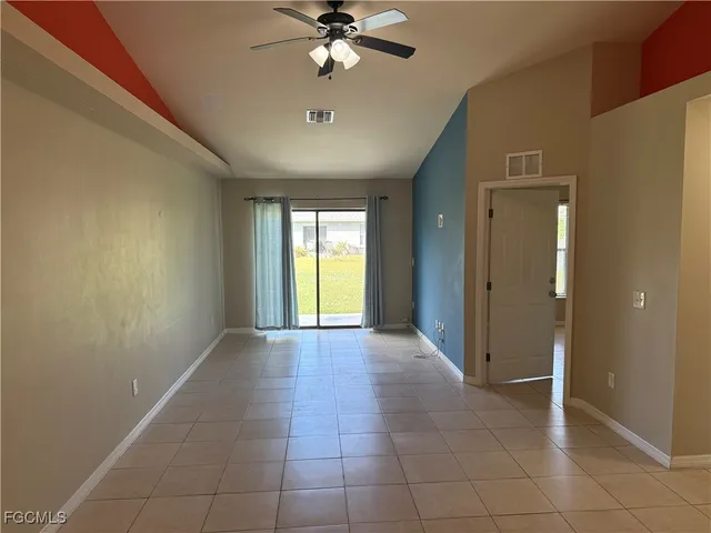 a view of a livingroom with a chandelier fan and windows