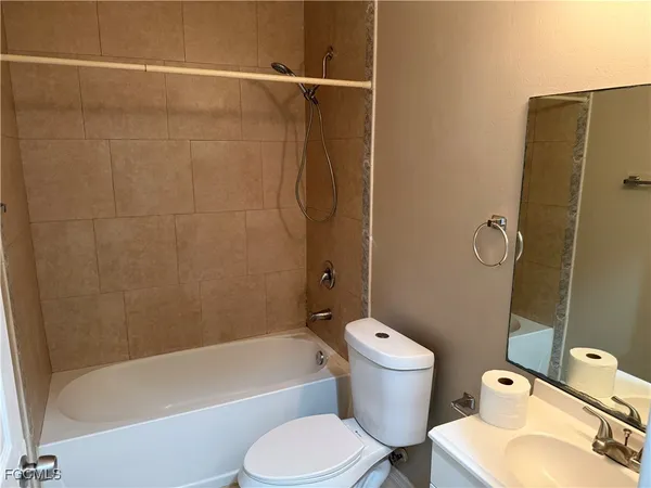 a white toilet sitting next to a bath tub and a shower