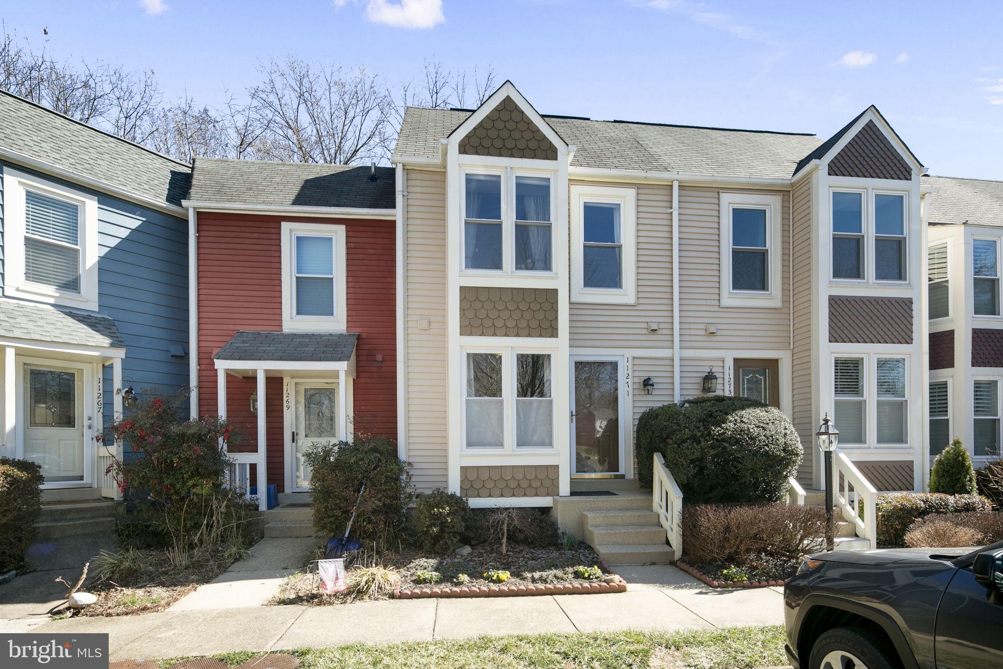 a front view of a house with yard and parking
