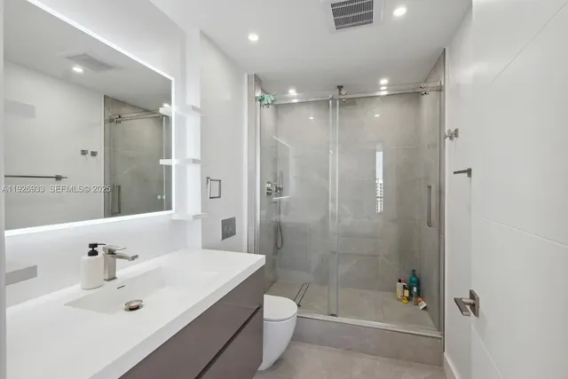 a bathroom with a bathtub shower sink mirror and toilet