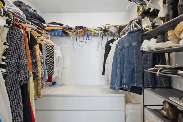 a view of walk in closet with clothes