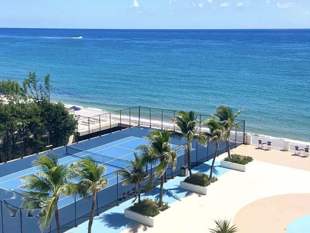 a living room with couches and kitchen view with wooden floor
