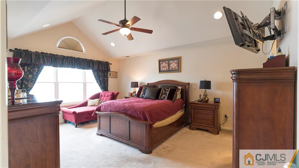 34 Raritan Reach Road, Unit 17 South Amboy, NJ 08879 - Photo 14 of 25 a spacious bedroom with a bed and a chandelier