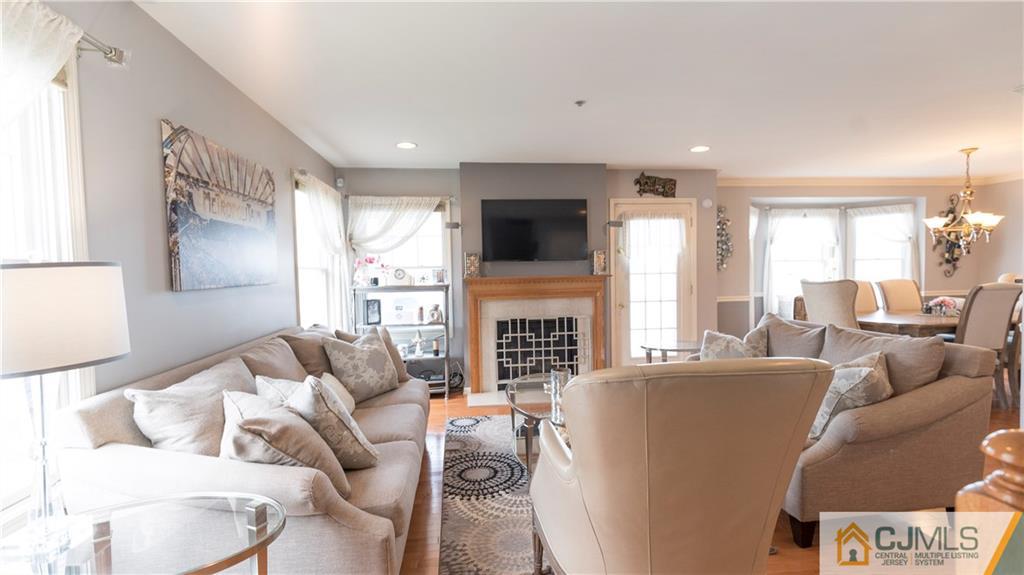 34 Raritan Reach Road, Unit 17 South Amboy, NJ 08879 - Photo 7 of 25 a living room with furniture a fireplace and a flat screen tv