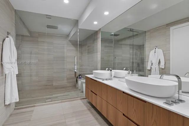 a bathroom with a double vanity sink mirror and shower