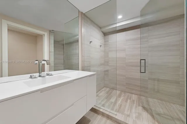 a bathroom with a sink shower and a mirror