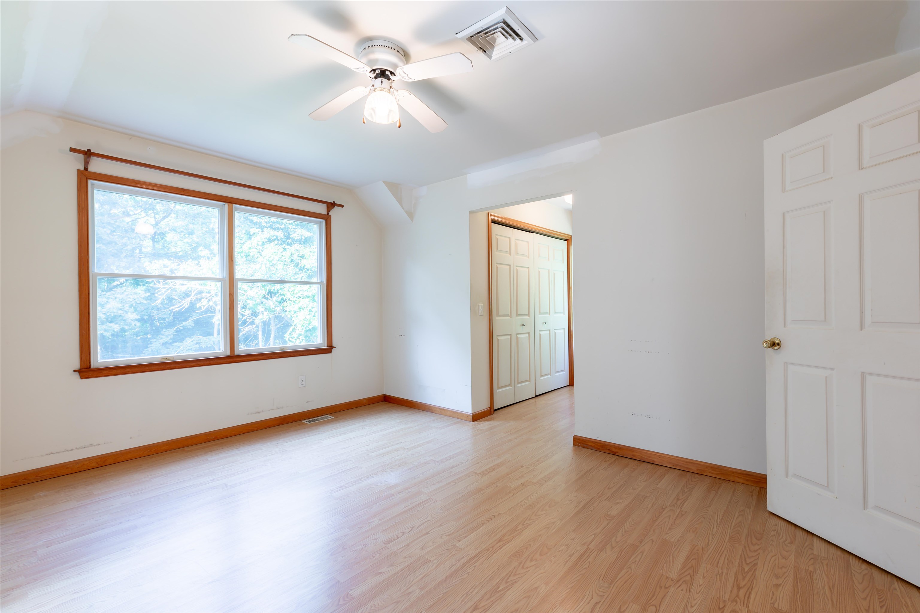 837 Weeks Landing Road Cape May, NJ 08204 - Photo 27 of 38 an empty room with wooden floor chandelier fan and windows