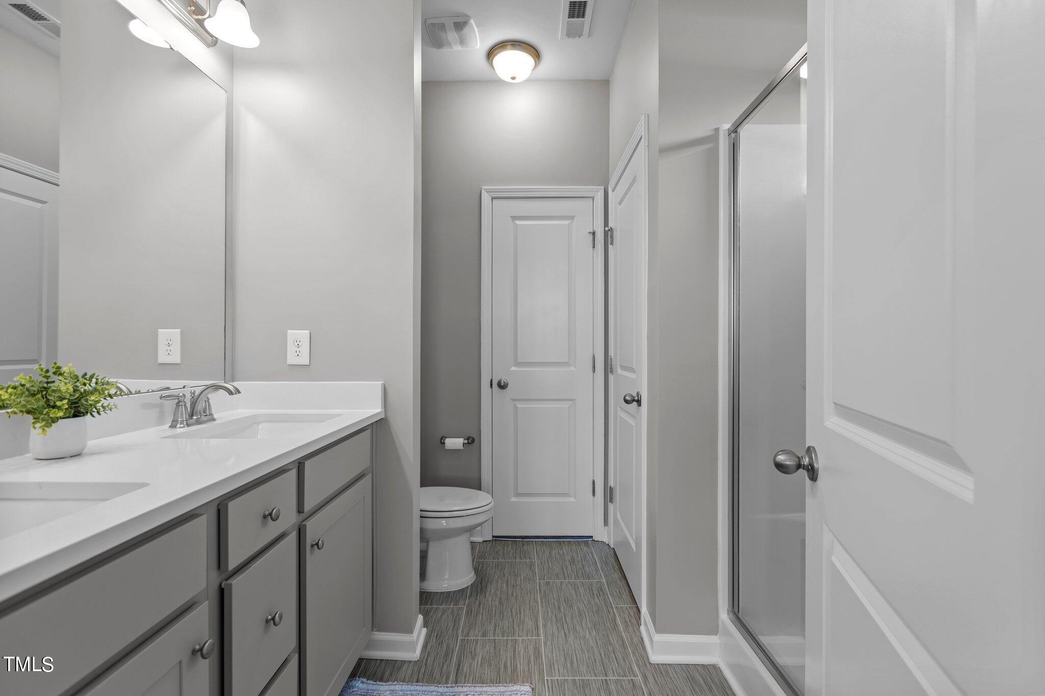 109 Longbow Drive Middlesex, NC 27557 - Photo 13 of 20 a bathroom with a granite countertop sink a toilet and shower