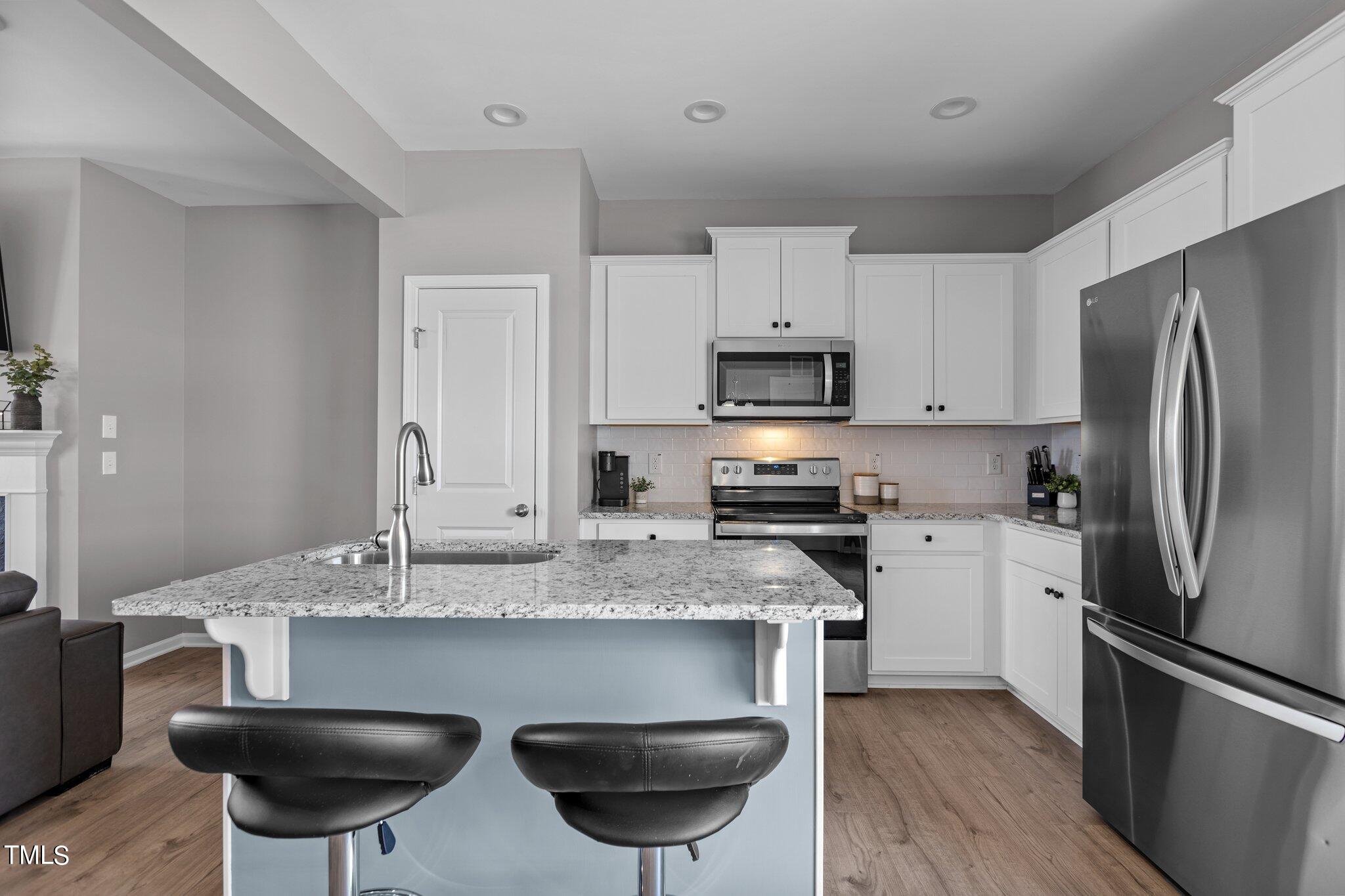 109 Longbow Drive Middlesex, NC 27557 - Photo 8 of 20 a kitchen with stainless steel appliances granite countertop a sink a stove a refrigerator and white cabinets