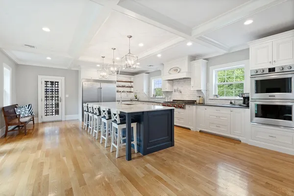 a large kitchen with stainless steel appliances granite countertop a large center island and a wooden floors