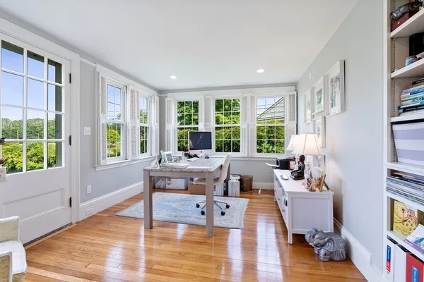 a living room with furniture large window and wooden floor