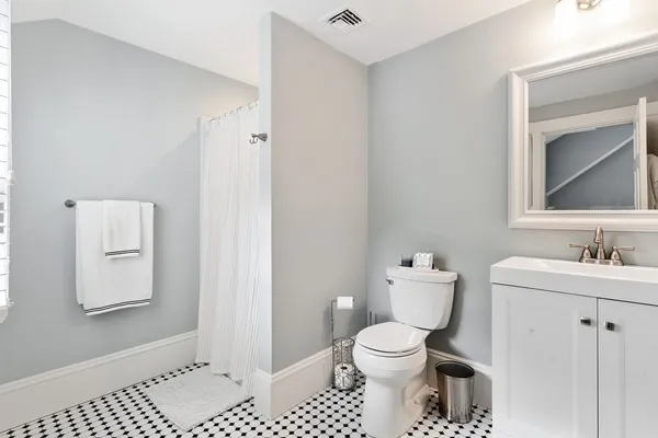 a bathroom with a toilet a sink and mirror