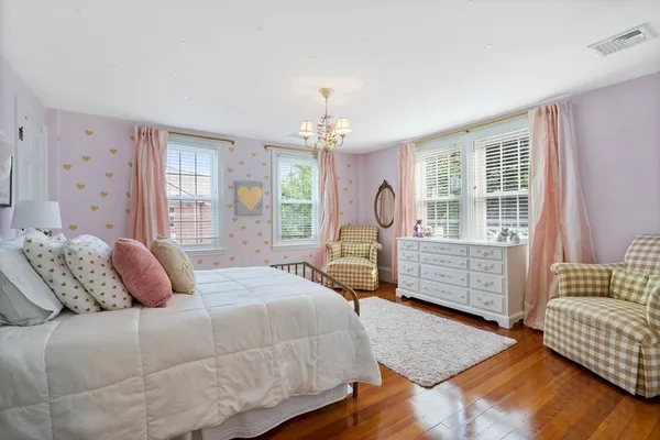 a bedroom with a large bed chandelier and windows