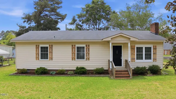a front view of a house with a garden and yard