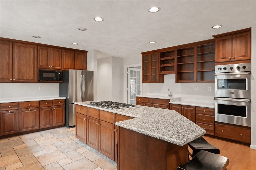 37 Old Planters Road Beverly, MA 01915 - Photo 13 of 42 a kitchen with stainless steel appliances granite countertop wooden cabinets a stove a sink and a oven