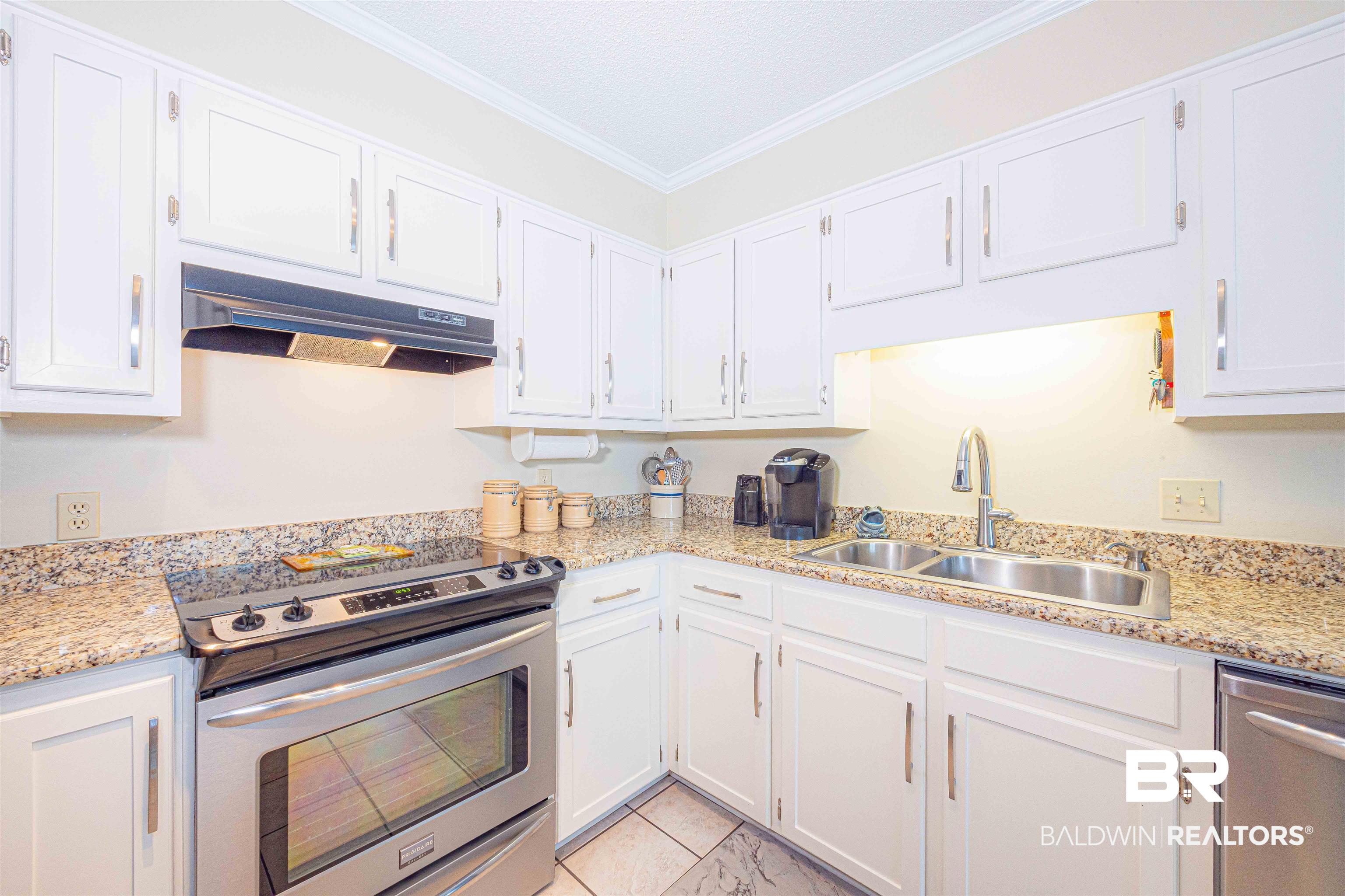 485 Ridgewood Drive Daphne, AL 36526 - Photo 20 of 38 Kitchen with white cabinets, under cabinet range hood, stainless steel appliances, and a sink
