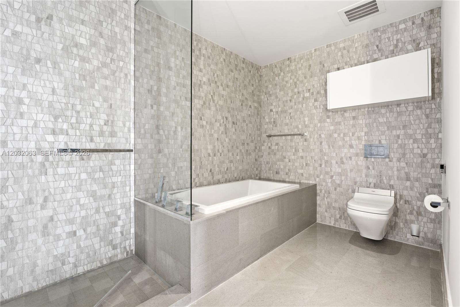 88 Southwest 7th Street, Unit 2302 Miami, FL 33130 - Photo 15 of 26 a bathroom with a toilet a sink and bathtub