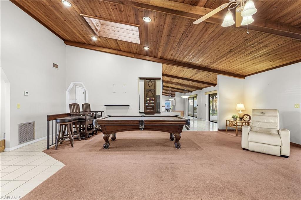 403 Southwest 34th Street Cape Coral, FL 33914 - Photo 14 of 32 Rec room with billiards, a wooden ceiling with exposed beams, light tile patterned flooring, a skylight, and light colored carpet