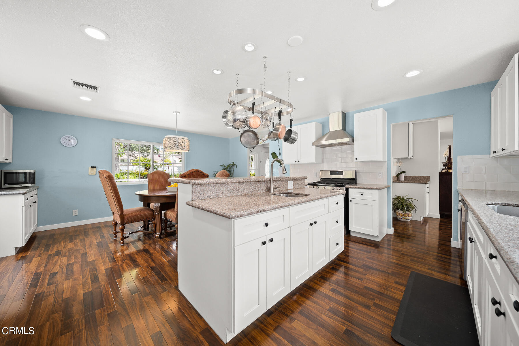 9765 Tujunga Canyon Boulevard Tujunga, CA 91042 - Photo 16 of 51 a kitchen with stainless steel appliances granite countertop a kitchen island hardwood floor sink stove dining table and chairs