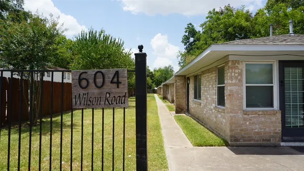 a view of a house with a wooden fence