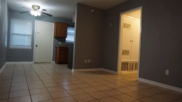 an empty room with closet and a chandelier fan