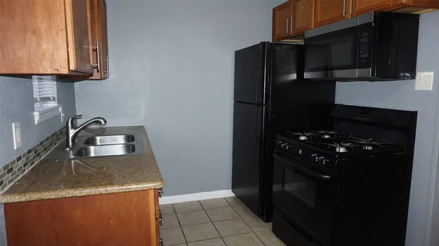 a kitchen with granite countertop a refrigerator and a stove
