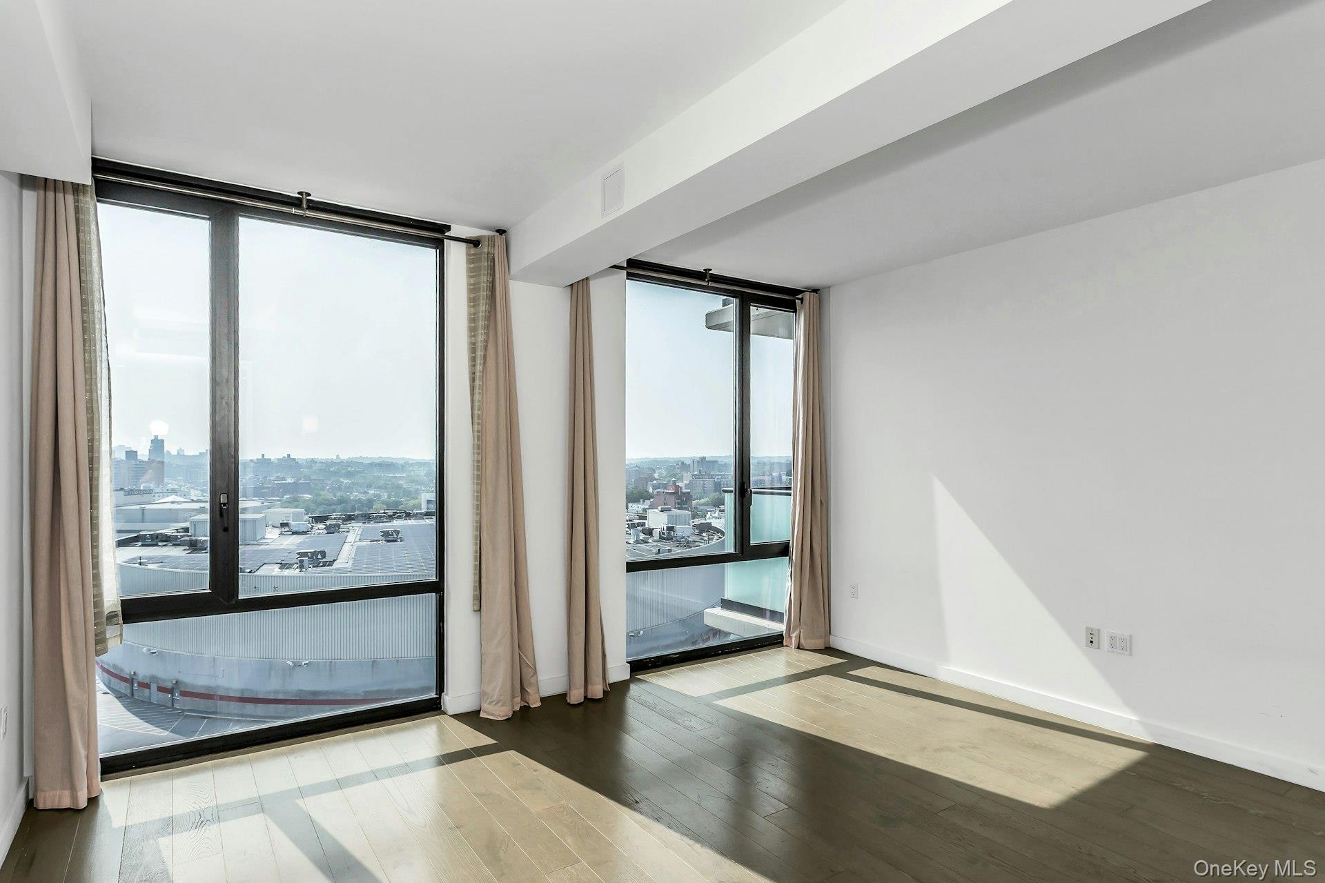 88-08 Justice Avenue, Unit 15N Queens, NY 11373 - Photo 5 of 20 a view of an empty room and window with an empty room