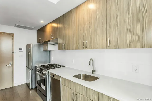a kitchen with a sink a refrigerator and a stove top oven