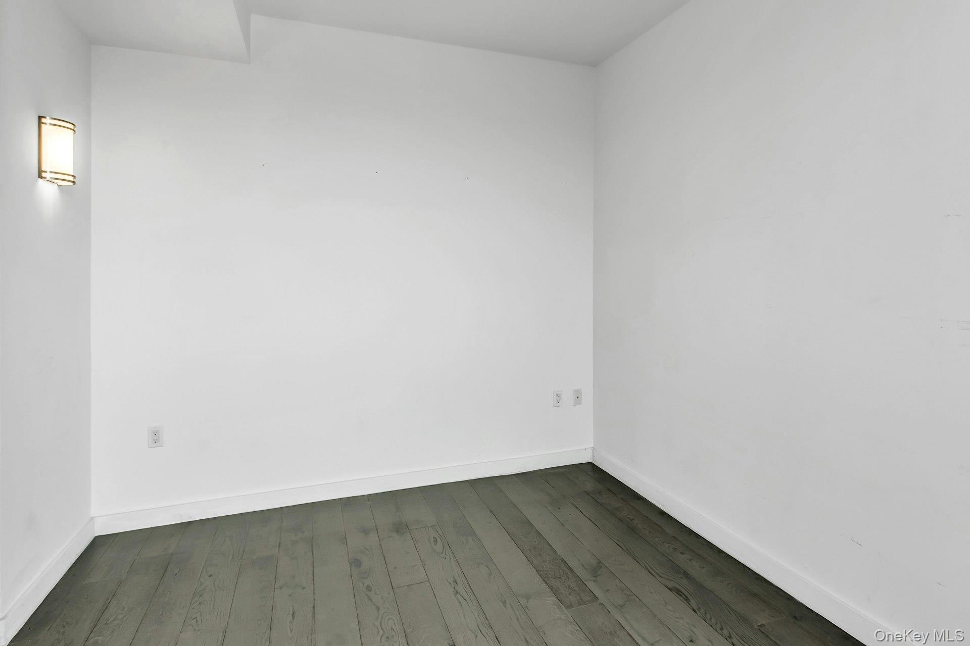 88-08 Justice Avenue, Unit 15N Queens, NY 11373 - Photo 10 of 20 a view of an empty room and wooden floor
