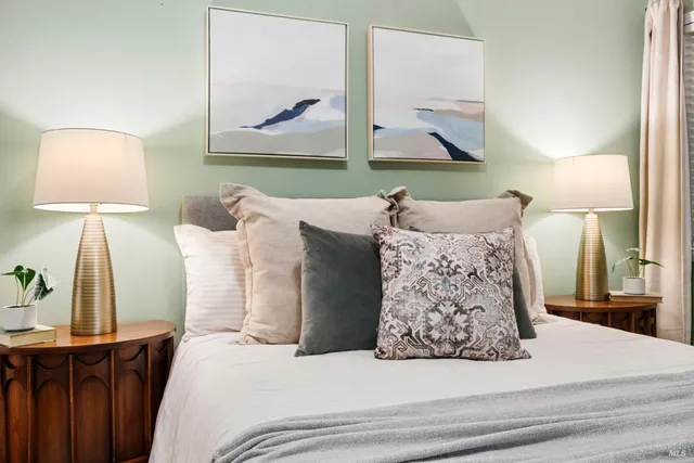 a bedroom with a bed and a lamp on dresser